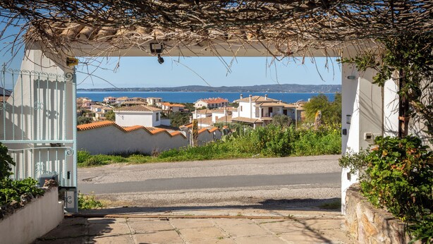 Une vue sur la côte, depuis une entrée abritée, avec un chemin de pierre menant à une route.
