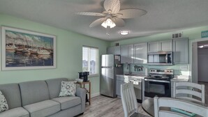A compact living space with a kitchenette, a sofa, a dining table, and a ceiling fan. - New owner Beautiful Beach view,Indoor pool & Hot Tub (Gulf Shores)