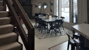 A dining area with a high ceiling, a fireplace, and a view of the outdoors. -  Great Montana Townhouse Skiing, Fly Fishing, Golf all in your backyard! (Bozeman)