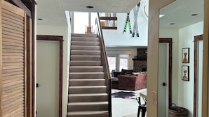 A spacious hallway with a staircase leading to a living area. -  Great Montana Townhouse Skiing, Fly Fishing, Golf all in your backyard! (Bozeman)