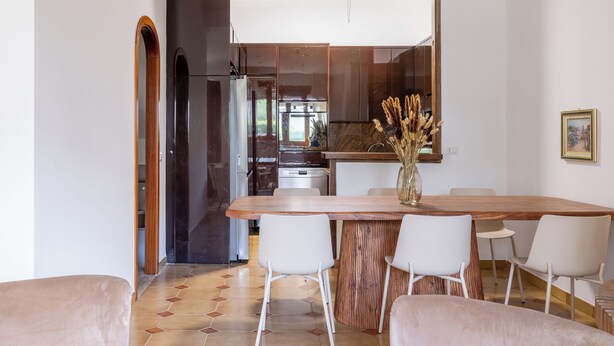 A modern kitchen with a wooden island, white chairs, and a dining table. - Spacious Villa with Pool, BBQ and Tennis Courts (Lazio)