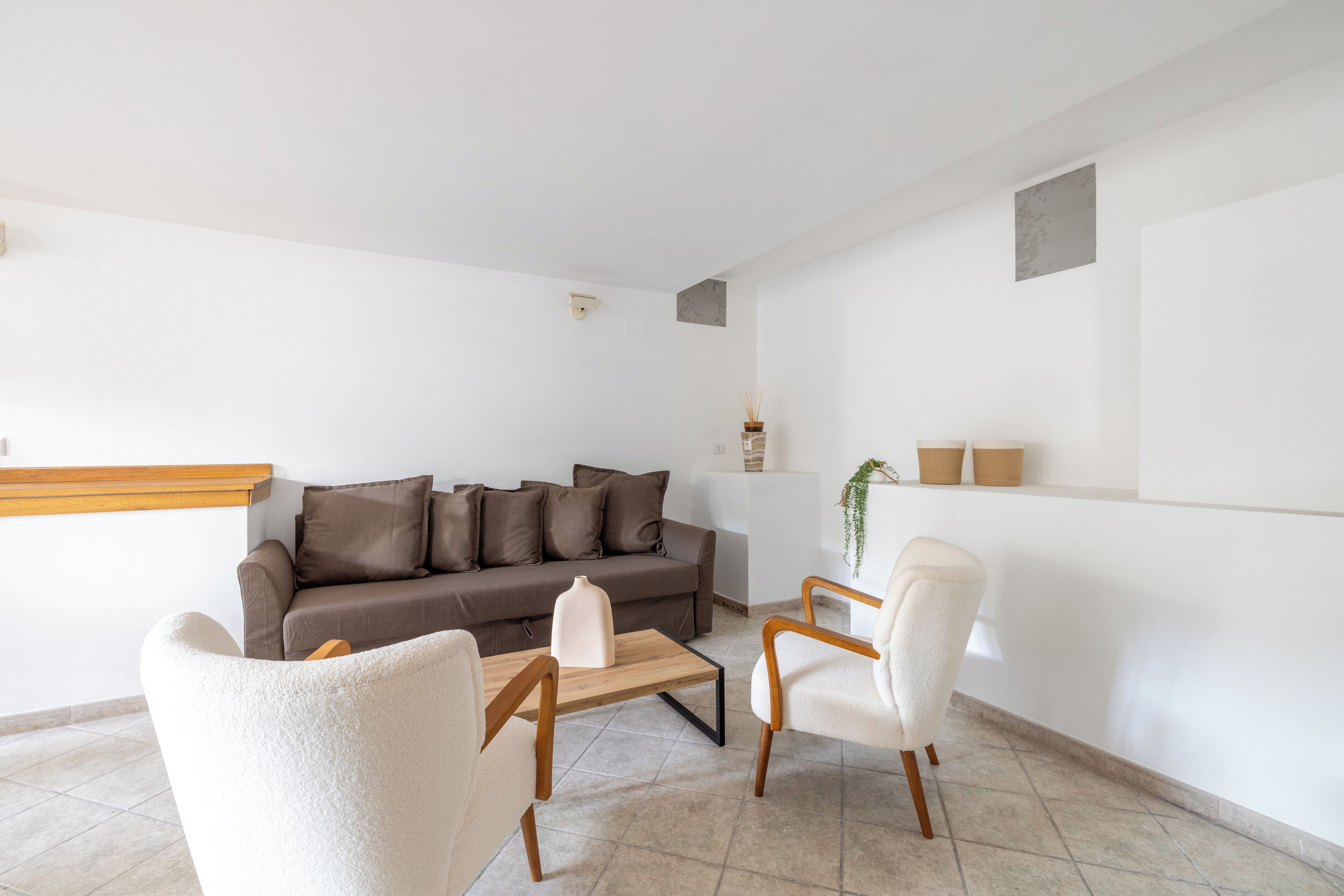 A modern living room with a sofa, two armchairs, a coffee table, and a small side table.