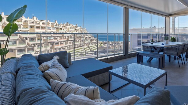 A spacious balcony with a clear view of the cityscape and sea.