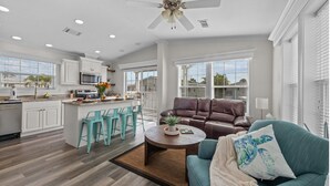 A spacious living area with a brown leather sofa, teal chairs, and a coffee table. - Sunny Gulf Coast Getaway-Near Beach-Shared Pool! (Fort Myers Beach)