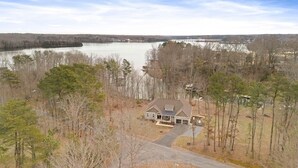Une maison avec une allée et un lac en arrière-plan.