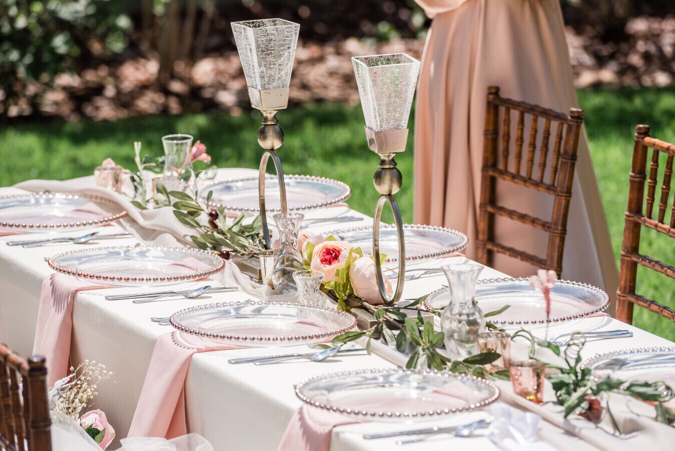 Taula ben posada per a un esdeveniment exterior formal, amb vetrería, plats i centrals florals.
