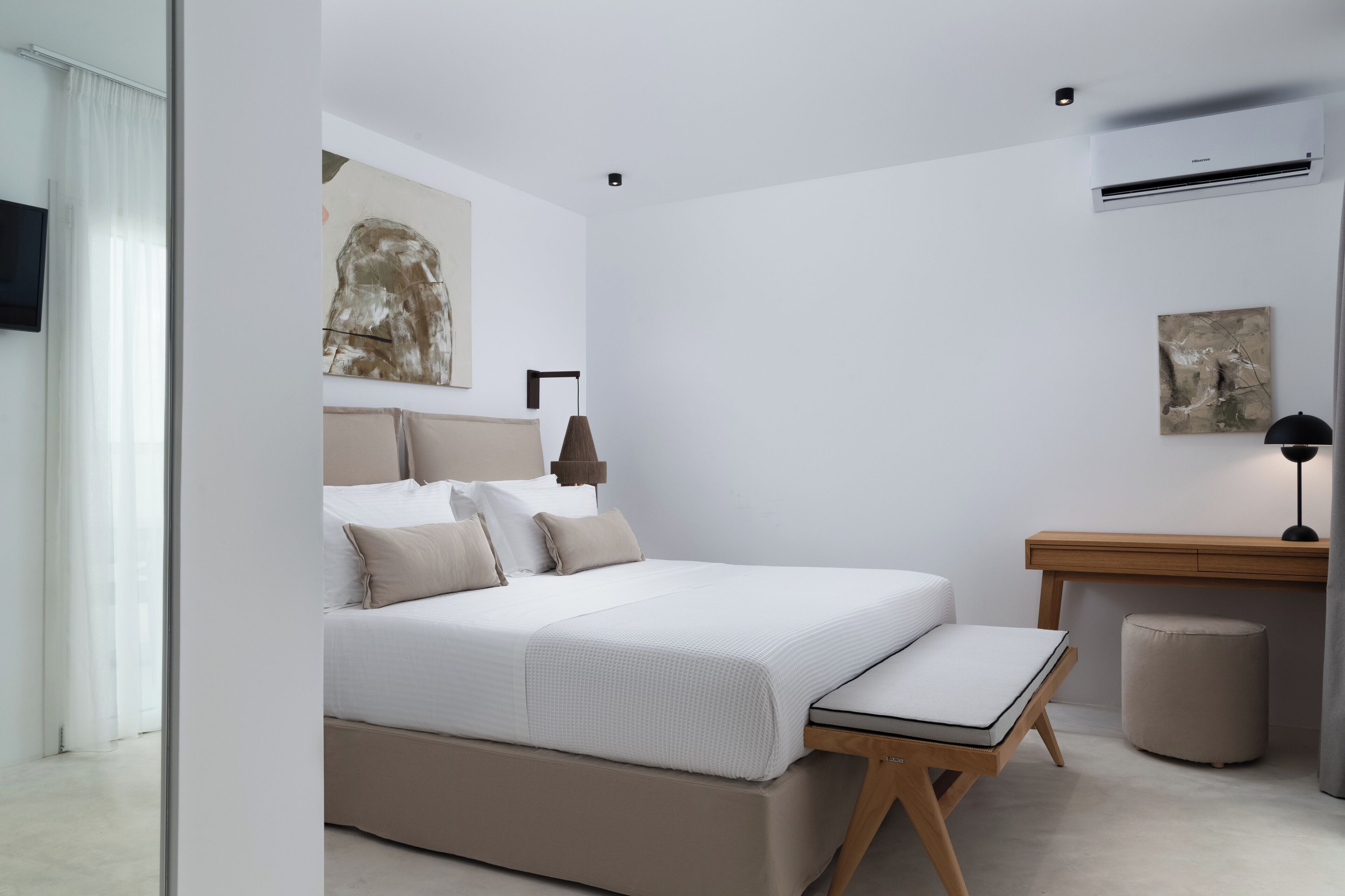 A modern bedroom with a bed, bedside table, and a small desk.