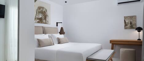 A modern bedroom with a bed, bedside table, and a small desk.