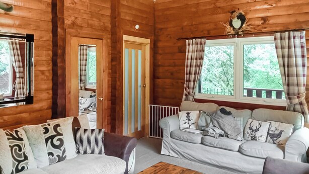 Een gezellig cabin interieur met twee banken, een houten salontafel en een raam met gordijnen.