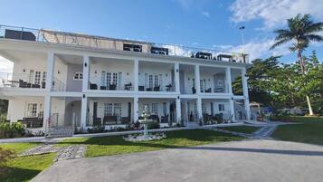 A multi-story building with balconies, a fountain, and a well-maintained lawn.