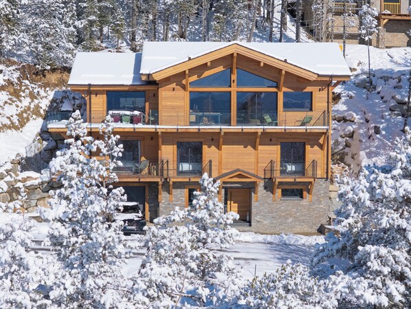 A multi-story wooden chalet with large windows and balconies, surrounded by snow-covered trees. - Brand-new, top-of-the-range chalet with panoramic views (sauna, steam room, billiards) (Les Angles)