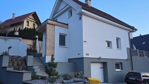 A modern two-story house with a garage, numbered 340, and a parked car.