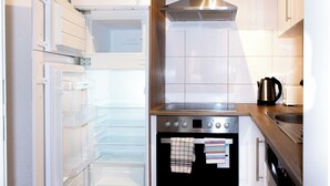 Een keuken met een inbouwoven, een roestvrijstalen afzuigkap en een vaatwasser.