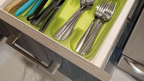 Eine Schublade mit ordentlich in Fächern angeordnetem Besteck.