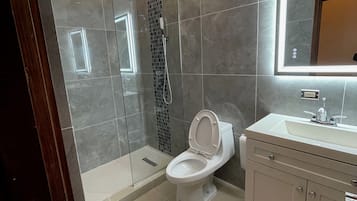 Chuveiro, toalhas de banho, sabonete, papel higiênico