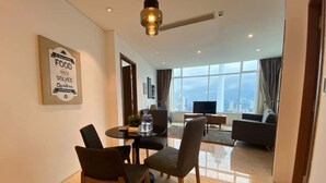 A modern hotel room with a dining area, a sofa, and a large window offering a city view. - SKY premium Suites KLCC  (Kuala Lumpur)