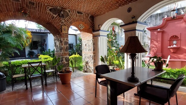 A patio with brick ceiling, tiled floor, and outdoor seating. - Hotel Nolasco (Antigua Guatemala)
