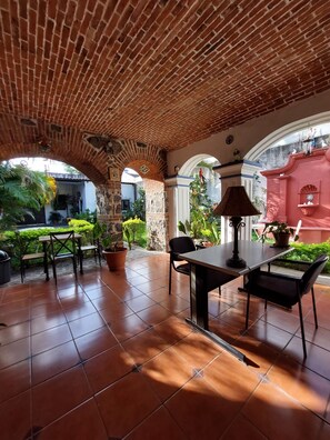 A patio with brick ceiling, tiled floor, and outdoor seating.