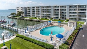 Ein Hotel mit Schwimmbad, umzäuntem Gelände, einem Steg mit Booten und Blick auf das Wasser.
