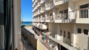 Een meerhoog hotel met balkons en uitzicht op zee.