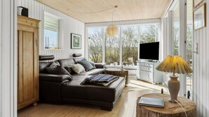 A modern living room with a leather sofa, a TV, and a lamp. - 3 bedroom awesome home in Ebeltoft (Ebeltoft)