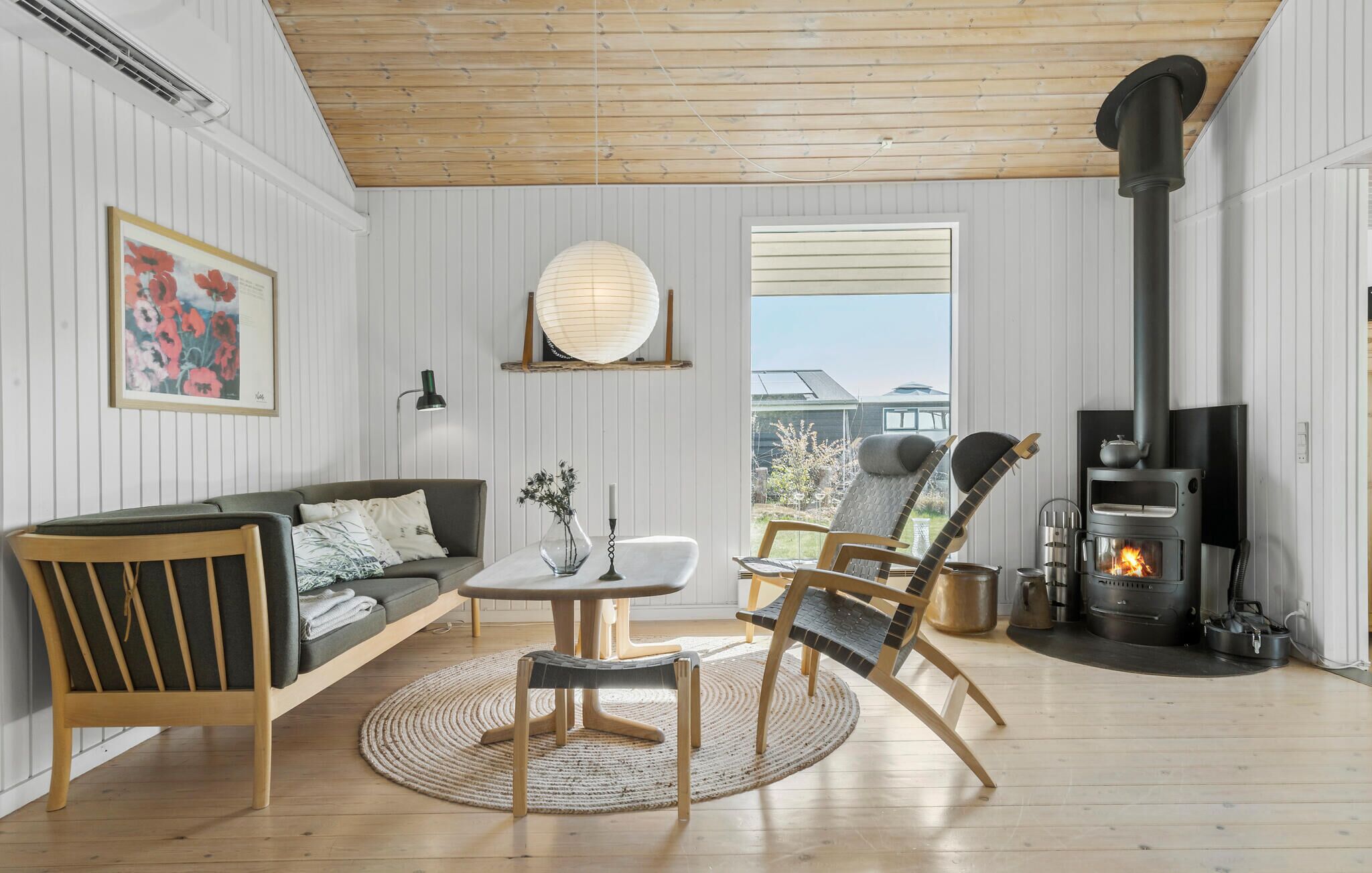 A cozy living room with a sofa, chairs, a table, and a fireplace.