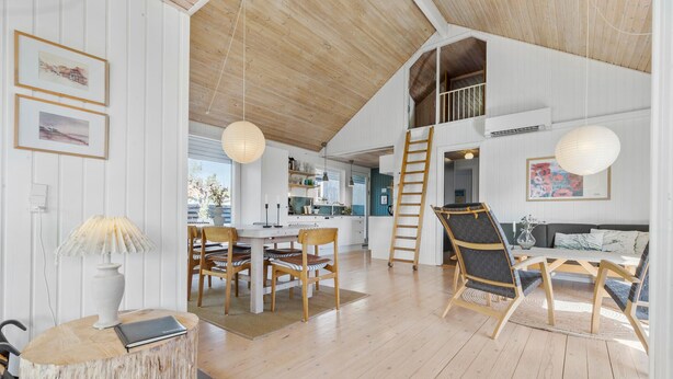A spacious loft-style room with a high ceiling, wooden floors, a dining area with a table and chairs, a lofted kitchen area, and a view of the outdoors. - 3 bedroom awesome home in Ebeltoft (Ebeltoft)