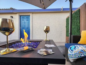 A patio area with a fire feature, two wine glasses, and a door labeled "Diana Guesthouse". - Large estate/3 Kings/Fenced yard w games/Grill/Firepit/Dogs OK/Boat parking (Page)