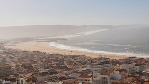 Un pueblo costero con playa y edificios de techos rojos.