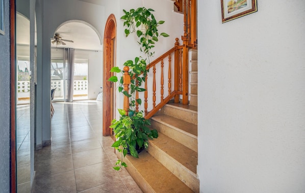 A staircase with wooden balusters and a potted plant on the right. - Amazing home in Vinaroz (Vinaroz)