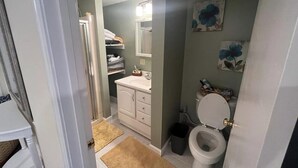 Une salle de bain équipée de toilettes, d’un lavabo et de meubles de rangement.
