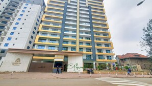 Un edificio de gran altura con varios balcones y una entrada protegida por un portón.