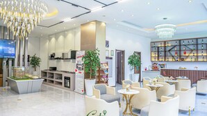 Un moderno vestíbulo de hotel con una recepción, zona de estar y un bar.