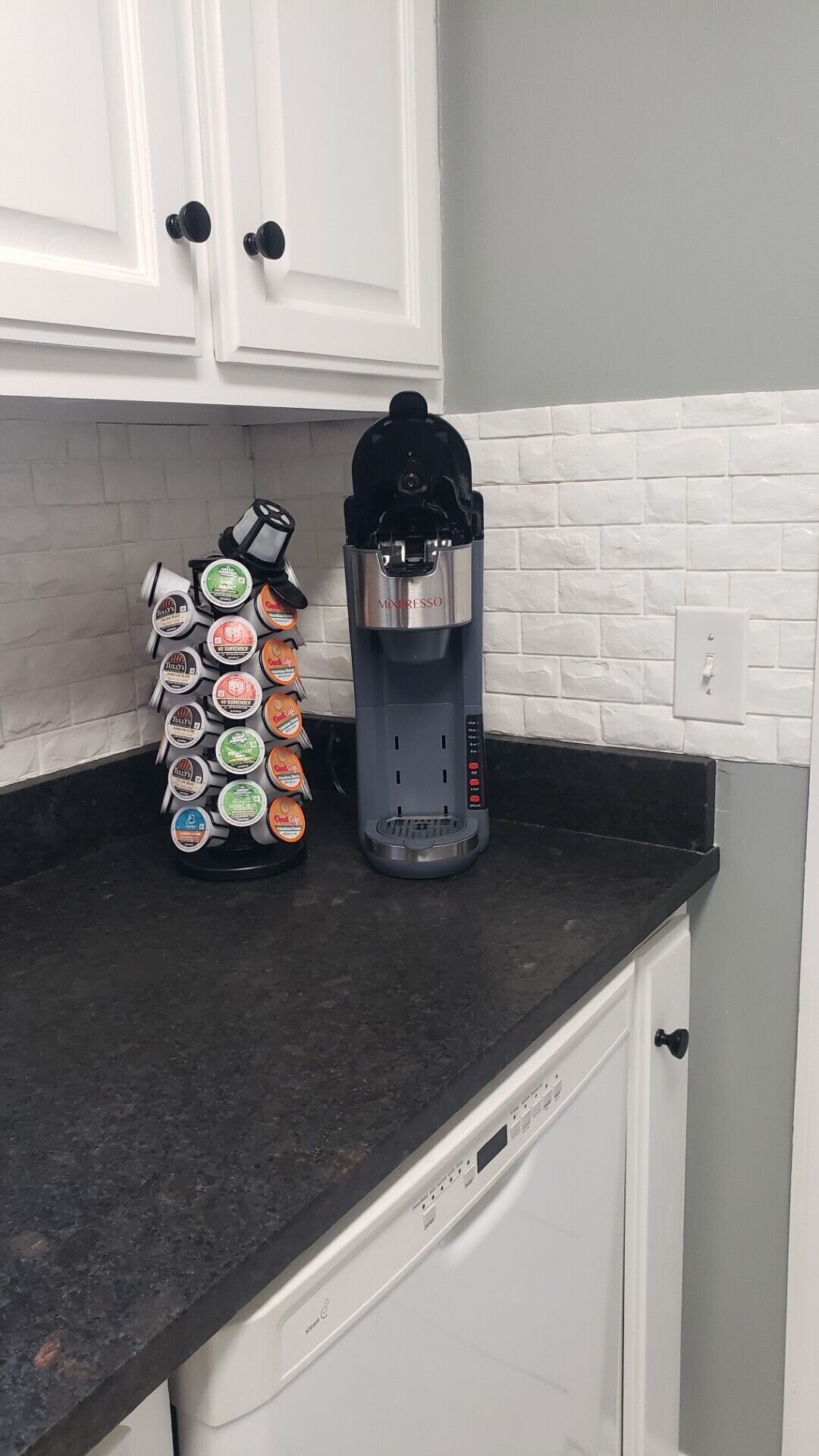 A kitchen with a coffee maker and a coffee pod holder on the counter.