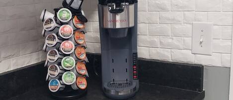 A kitchen with a coffee maker and a coffee pod holder on the counter.