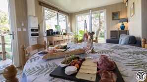 A dining area with a table set for a meal, featuring various cheeses, meats, and olives. - Les Collines du Pastel (VERFEIL)