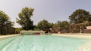 A clear swimming pool with lounge chairs and a wooden deck. - Les Collines du Pastel (VERFEIL)