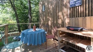 A wooden deck with a table and chairs, a sign indicating 'Place Toulouse Lautrec', and a small window. - Les Collines du Pastel (VERFEIL)