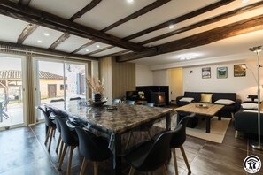 Relax in this inviting living area with a large dining table, comfortable sofa, and modern fireplace.