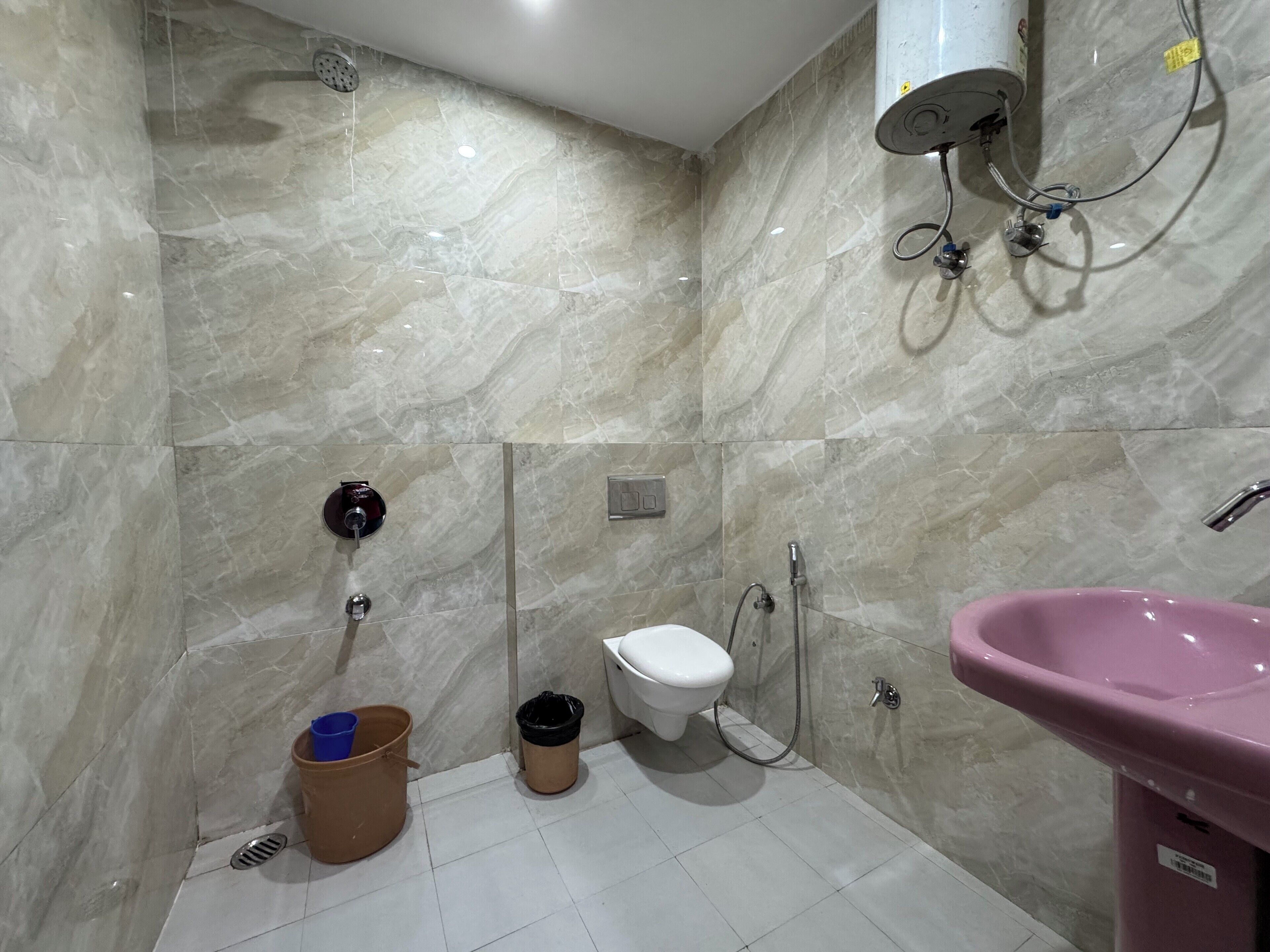 A bathroom with a toilet, bidet, shower, and sink.