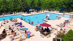 Ett poolområde med flera pooler, solstolar och parasoller.