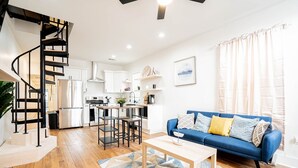 A modern apartment with a kitchen, dining area, and living room.