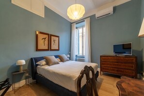 A bedroom with a bed, a dresser, a television, and two wall-mounted artworks. - Santa Maria alle Fornaci - FromHometoRome (Rome)