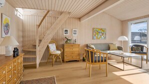 A wooden interior with a staircase, a sofa, a dining table, and a dresser. - 2 bedroom gorgeous home in Juelsminde (Juelsminde)