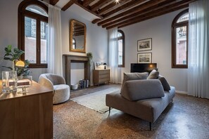 Un salon avec une cheminée, un canapé, un fauteuil et un téléviseur.