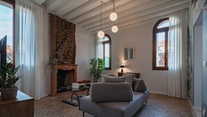 A living room with a fireplace, a sofa, and a coffee table. - Ca' Vida Trifora (Venezia)