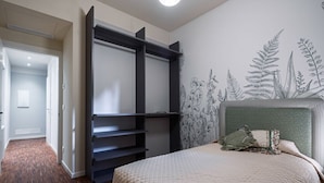 A bedroom with a bed, a wardrobe, and a wall with a botanical mural. - Ca' Vida Trifora (Venezia)