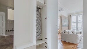 A modern apartment with a bathroom featuring a glass shower enclosure, a white interior, and a wooden floor. - Blueground | Bastille, near shops & park (Paris)