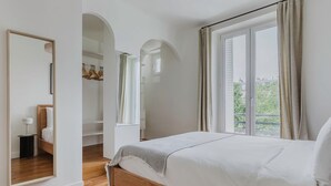 A bedroom with a wooden bed, a wardrobe, and a mirror. - Blueground | Bastille, near shops & park (Paris)