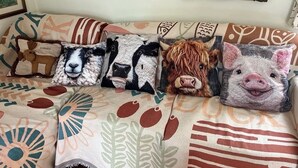 Un sofá con cojines estampados y una manta decorativa.